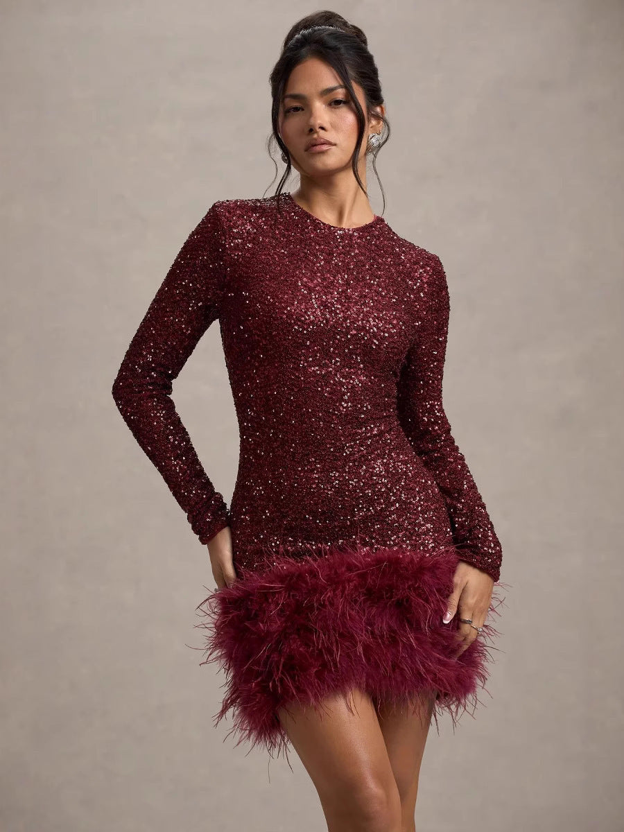 Woman wearing a burgundy sequin dress with feathered skirt against a neutral background