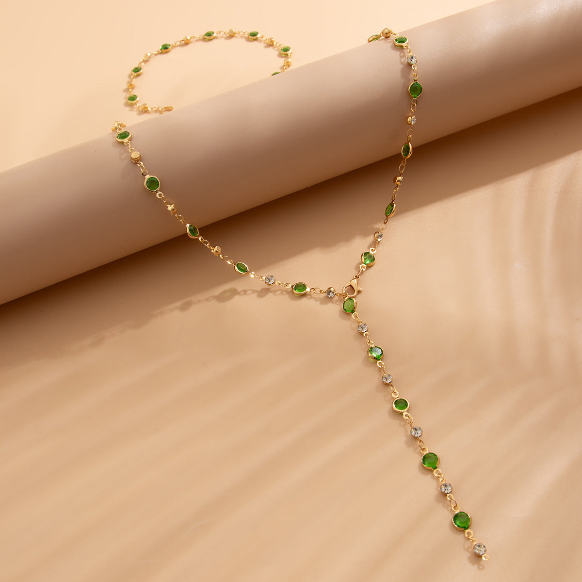 Gold necklace with green gemstones 