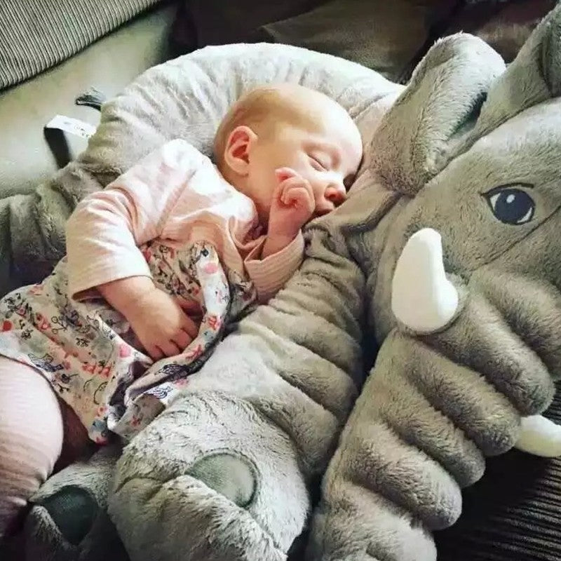 Baby sleeping on a large gray stuffed elephant