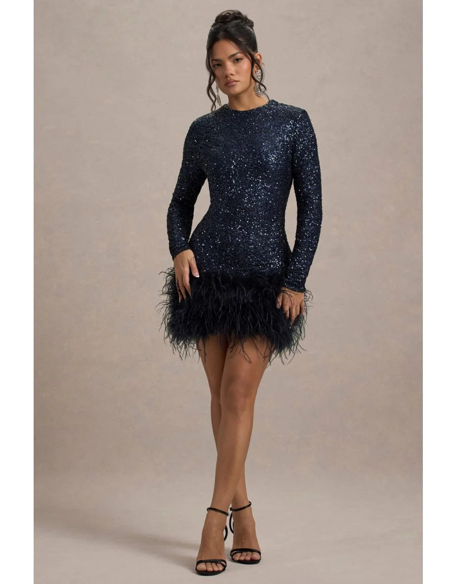 Woman wearing a navy sequin dress with feather details on a beige background