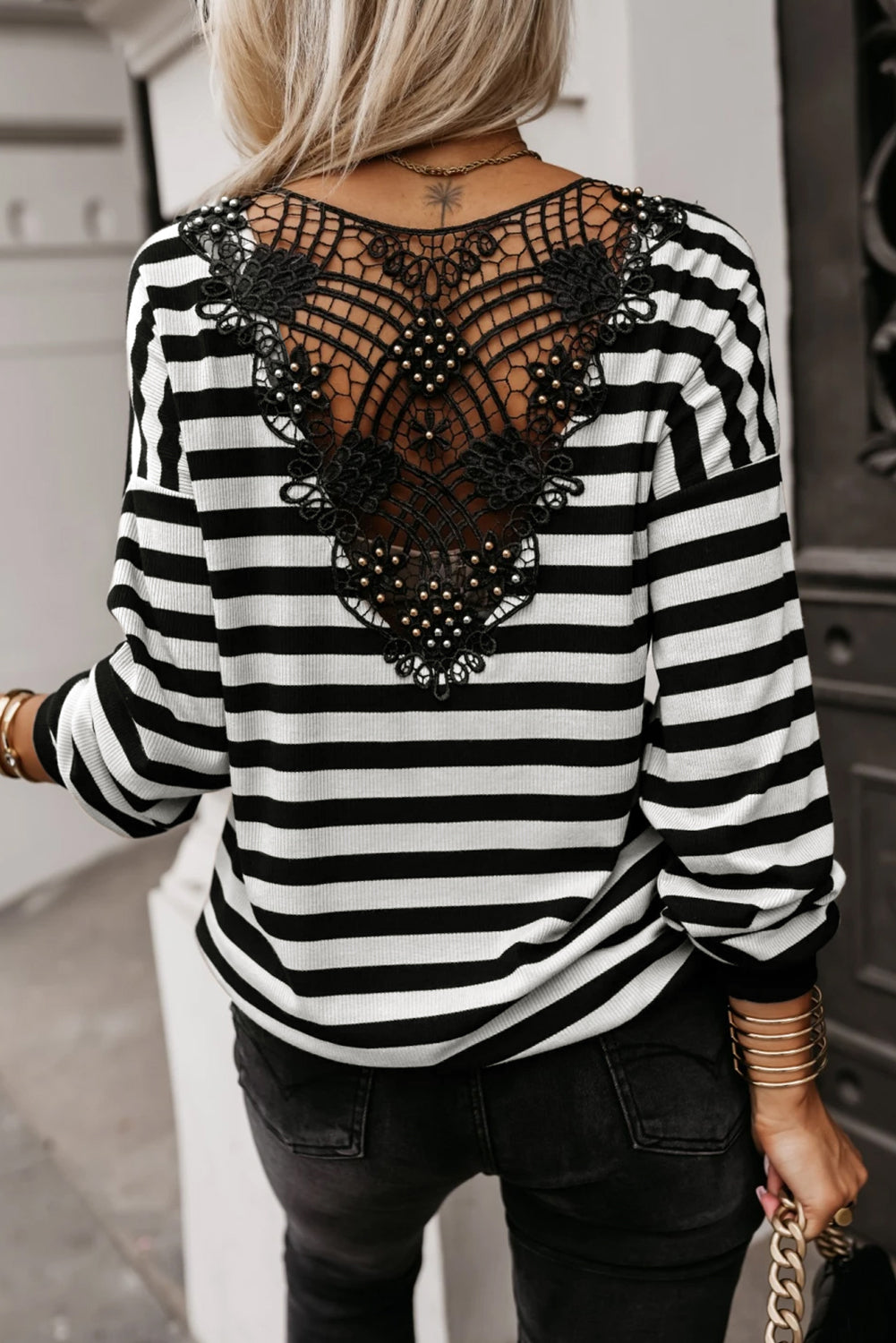 Black and white striped v-neck shirt with lace detailing on the back