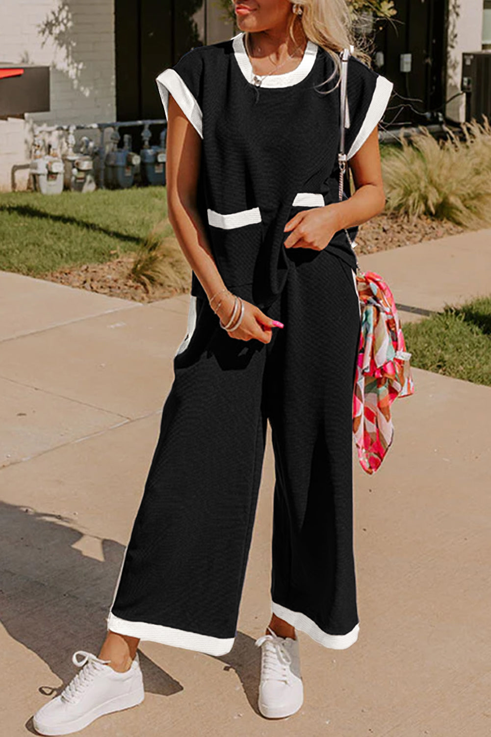 Woman wearing a black outfit with white trim