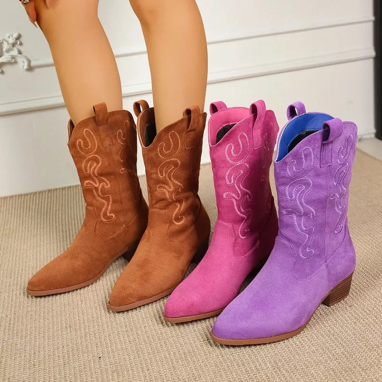 Pair of brown cowboy boots next to pink and purple cowboy boots 