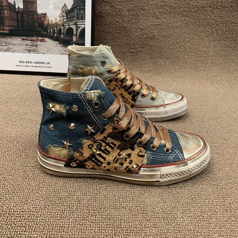 Pair of high-top sneakers with decorative elements on a textured surface.