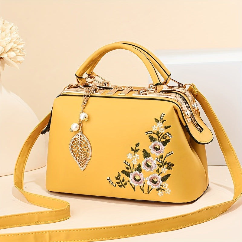 Yellow crossbody handbag with floral embroidery and a leaf charm 