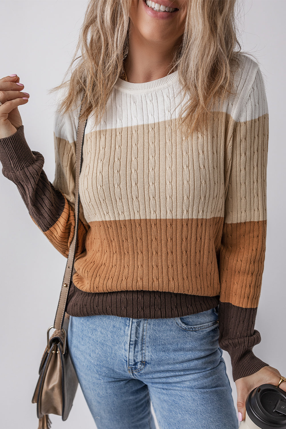 Person wearing a striped sweater with brown, beige, and white colors 
