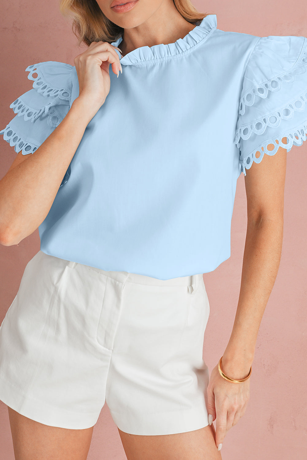 Woman wearing a light blue blouse with lace details 