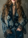 Person wearing a blue floral blouse with intricate detailing on a gray background