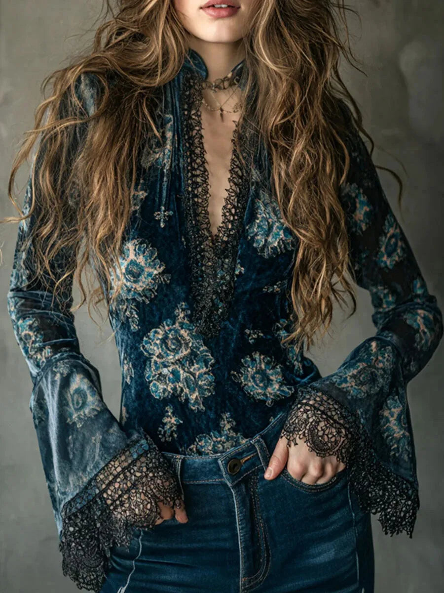 Person wearing a blue floral blouse with intricate detailing on a gray background