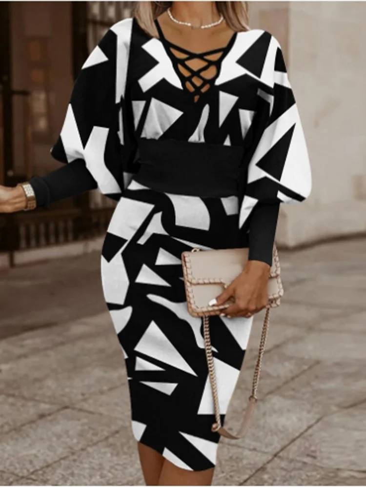 Woman wearing a black and white V-Neck geometric patterned dress with vintage balloon Sleeves