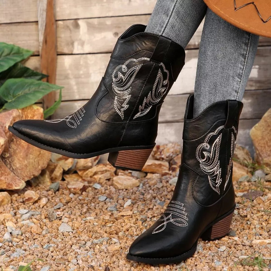Black cowboy boots with intricate white embroidery 